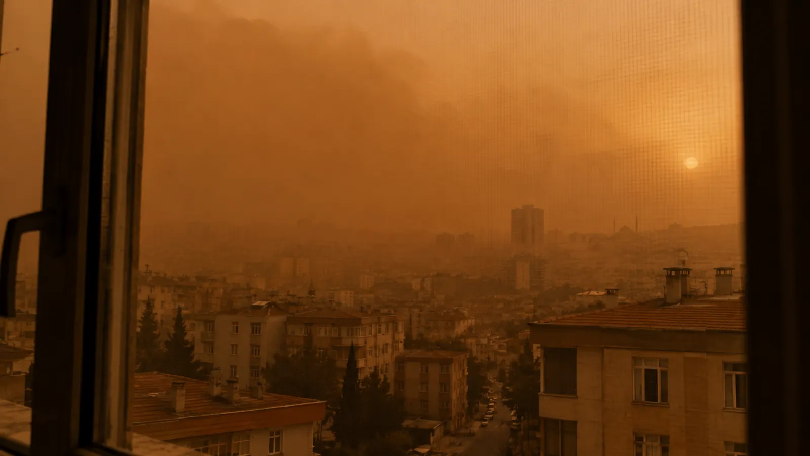 Çöl tozuyla turuncuya dönmüş Gaziantep gökyüzü, apartman penceresinden